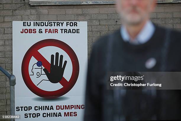 Labour leader Jeremy Corbyn speaks to the media at the Tata Sports Club next to a sign against China's dumping of Steel on March 30, 2016 in Port...