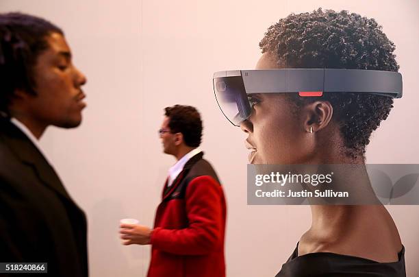 Attendees walk by an image of the Microsoft HoloLens augmented reality viewer during the 2016 Microsoft Build Developer Conference on March 30, 2016...