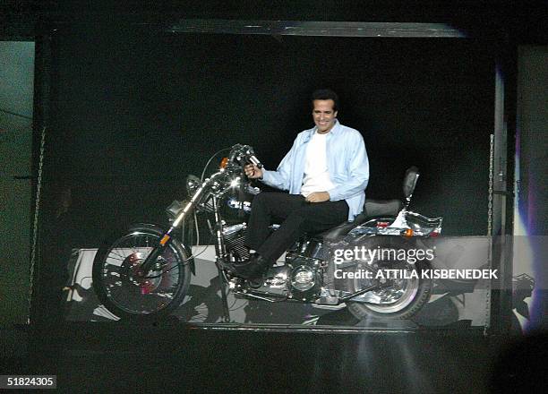 Internationally-celebrated magican American David Copperfield sits on a Harley-Davidson motorcycle in a giant box 04 December 2004 during his show,...