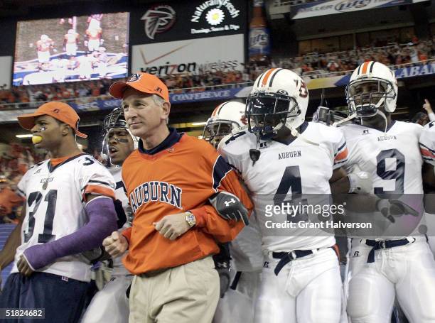 Head coach Tommy Tuberville of the Auburn Tigers leads his team onto the field against the Tennessee Volunteers in the 2004 SEC Championship Game at...