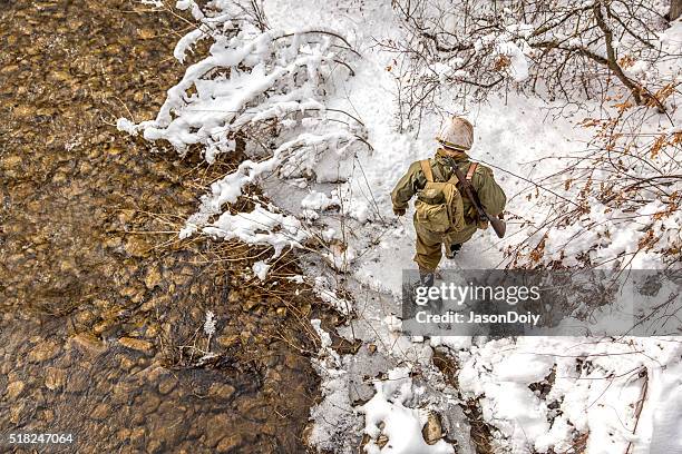 world war ii: soldier crossing creek in the snow - 1944 stock pictures, royalty-free photos & images