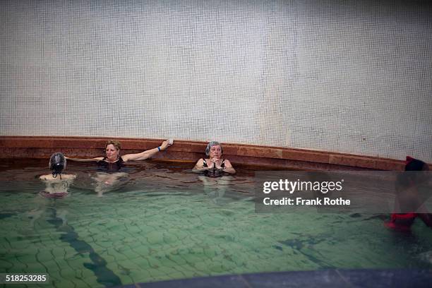 people enjoy a hot bath in the gellert bath - piscine thermale photos et images de collection