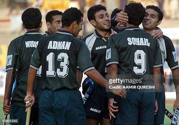 Pakistani field hockey players Sohail Abbas and Adnan Maqsood celebrate with teammates after scoring a goal against New Zealand during the six-nation...