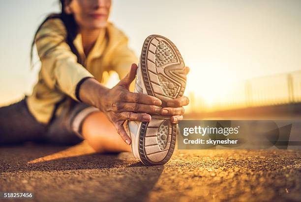 close-up of woman stretching her leg at sunset. - woman stretching sunset bildbanksfoton och bilder
