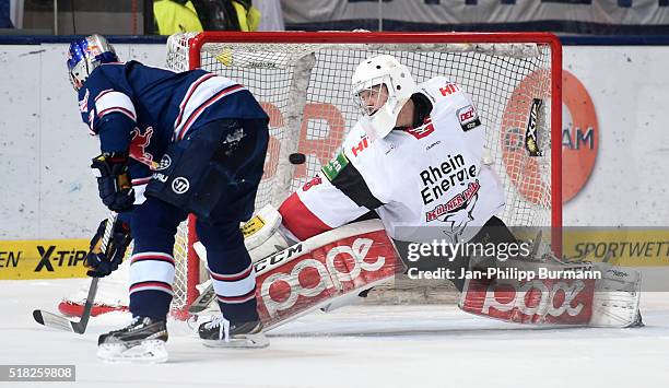 Michael Wolf of EHC Red Bull Muenchen scores the 4:1 against Gustaf Wesslau of the Koelner Haien during the game between the EHC Red Bull Muenchen...