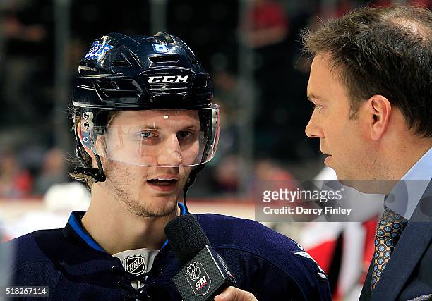 Jacob Trouba of the Winnipeg Jets does an pre-game interview with Sportsnet reporter Elliotte Friedman prior to NHL action against the Ottawa...