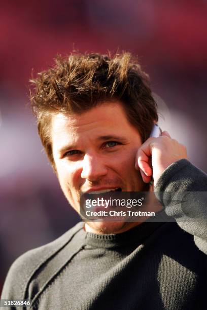 Nick Lachey talks on the phone during pregame before the New York Jets played the Houston Texans at Giants Stadium on December 5, 2004 in East...