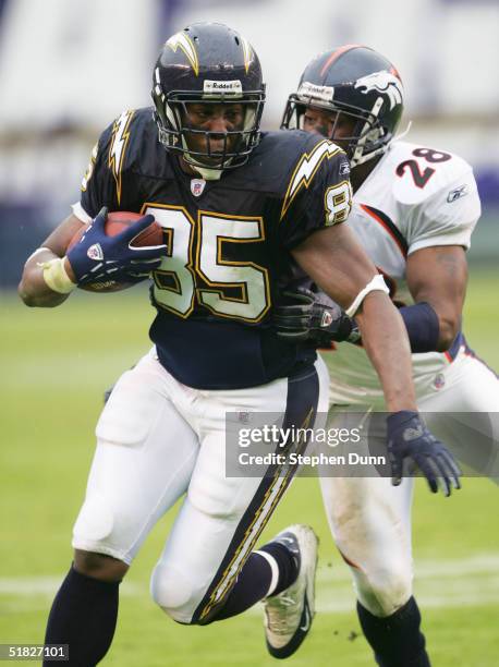 Tight end Antonio Gates of the San Diego Chargers carries the ball as defensive back Kenoy Kennedy of the Denver Broncos defends on December 5, 2004...