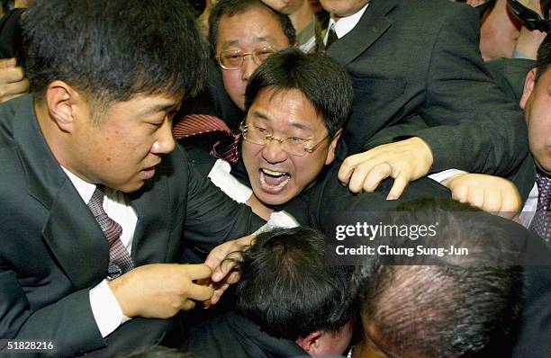 Members of South Korea's ruling Uri Party scuffle with opposition Grand National Party members during a move to present a controversial bill calling...