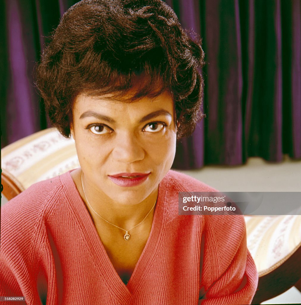 American singer and actress Eartha Kitt posed wearing a red vneck
