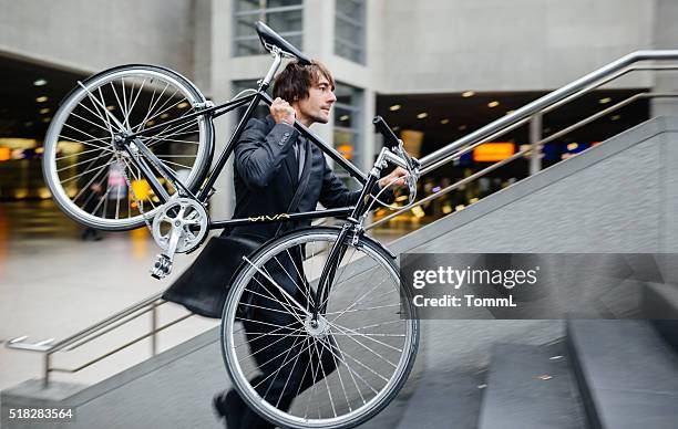 businessman carrying bicycle on his shoulder - carrying bike stock pictures, royalty-free photos & images