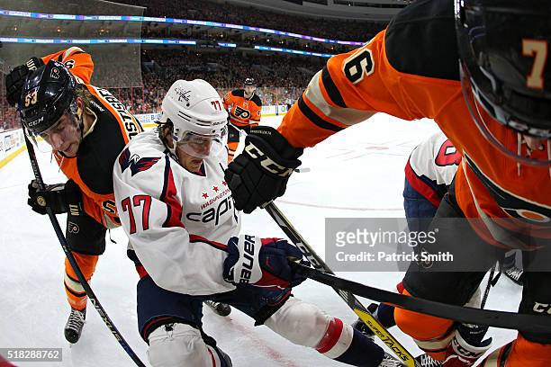 Oshie of the Washington Capitals is checked by Chris VandeVelde and Shayne Gostisbehere of the Philadelphia Flyers during the first period at Wells...
