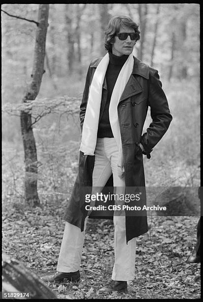 Algerian-born fashion designer Yves Saint Laurent poses outdoors in a leather trenchcoat and sunglasses in the CBS special 'The Paris Collections...