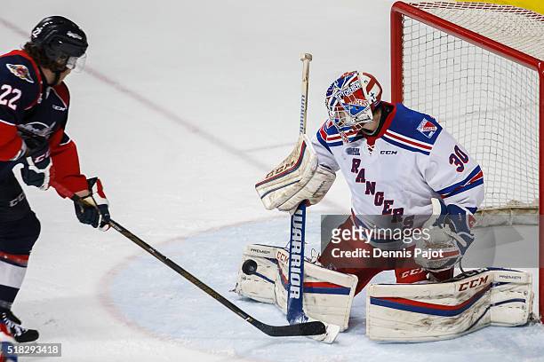 Forward Brendan Lemieux of the Windsor Spitfires slips the puck past goaltender Dawson Carty of the Kitchener Rangers during game 4 of the Western...