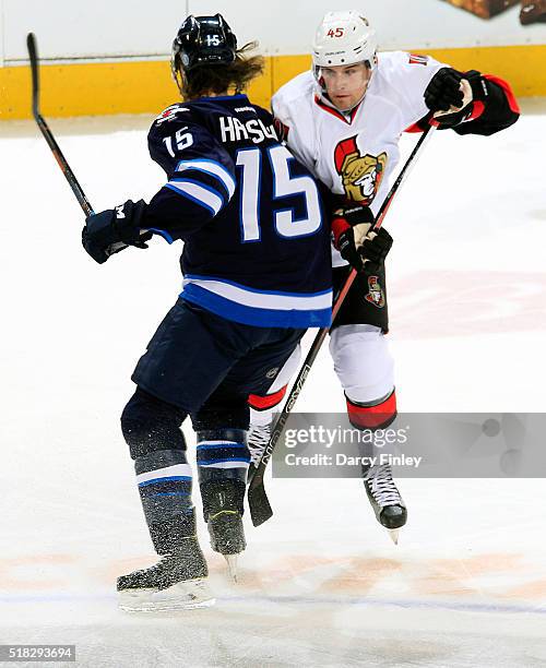 Matt Halischuk of the Winnipeg Jets and Chris Wideman of the Ottawa Senators collide at centre ice during second period action at the MTS Centre on...