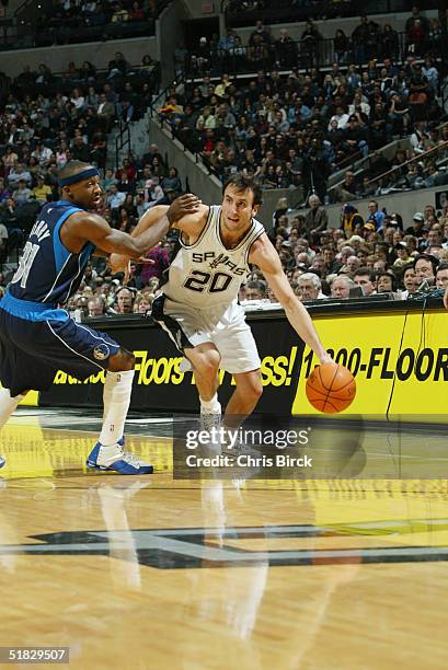 Emanuel Ginobili of the San Antonio Spurs drives around Jason Terry of the Dallas Mavericks during the game at SBC Center on November 24, 2004 in San...
