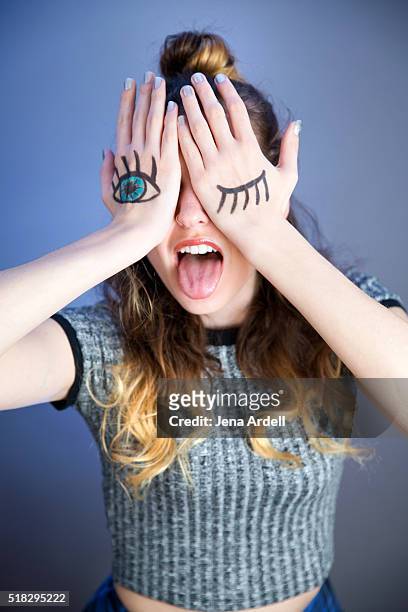 woman covering face with hands with eyes drawn on them - winking eye stock pictures, royalty-free photos & images