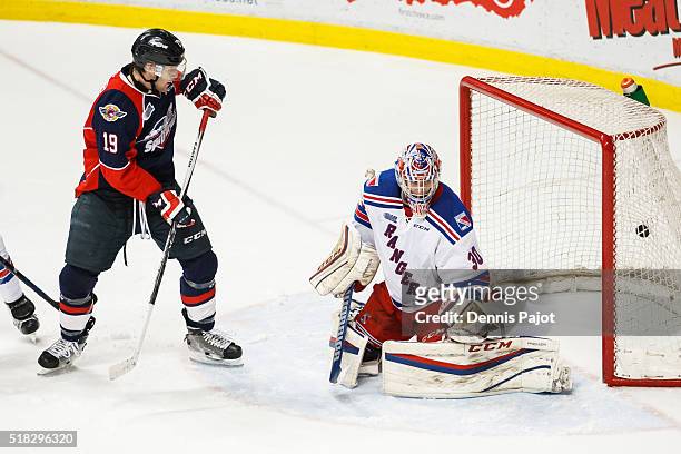 Christian Fischer of the Windsor Spitfires watches as the puck slips by goaltender Dawson Carty of the Kitchener Rangers during game 4 of the Western...