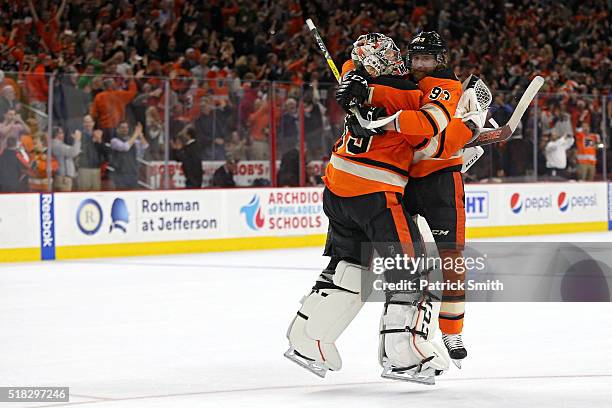 Goalie Steve Mason and teammate Jakub Voracek of the Philadelphia Flyers celebrate after defeating the Washington Capitals at Wells Fargo Center on...