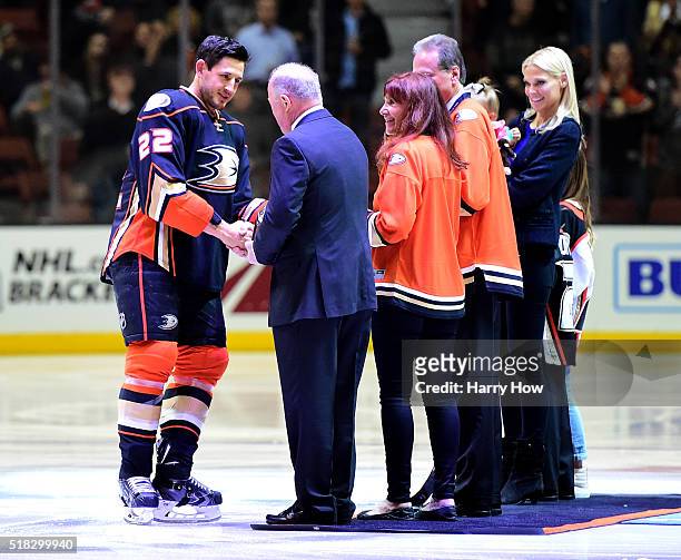Shawn Horcoff of the Anaheim Ducks receives a gift from General Manager Bob Murray in celebration of his 1000th NHL game before the game against the...