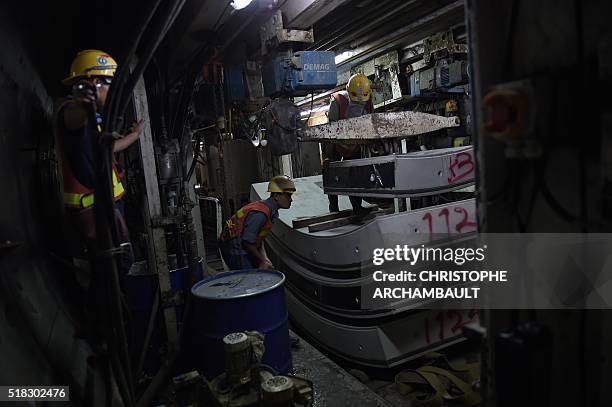 This picture taken on March 11, 2016 shows labourers working in a tunnel under construction along the current extension of the Metropolitan Rapid...