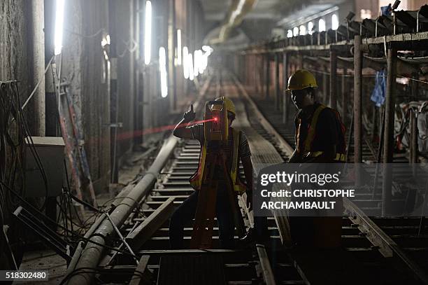 This picture taken on March 11, 2016 shows labourers working in a tunnel under construction along the current extension of the Metropolitan Rapid...