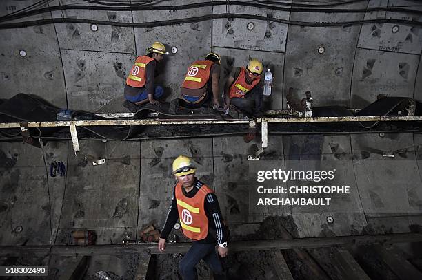 This picture taken on March 11, 2016 shows labourers working in a tunnel under construction along the current extension of the Metropolitan Rapid...