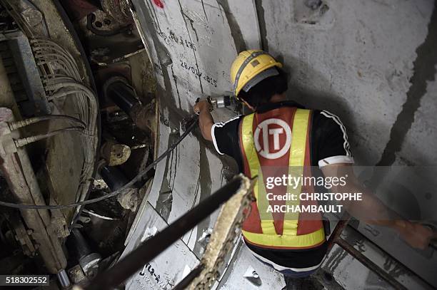 This picture taken on March 11, 2016 shows workers preparing curved concrete segments to be attached to form the inner surface of a tunnel being dug...