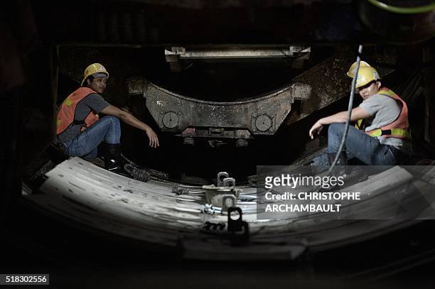 This picture taken on March 11, 2016 shows workers preparing curved concrete segments to be attached to form the inner surface of a tunnel being dug...