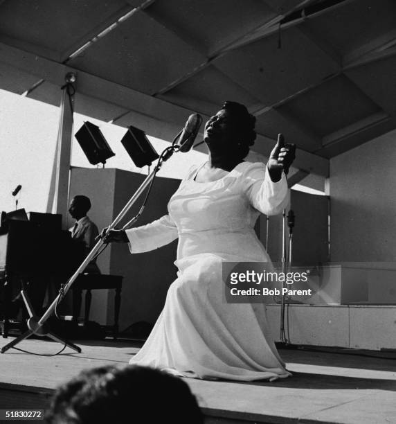 American gospel singer Mahalia Jackson sings on bended knee with her arms outstretched at the Newport Jazz Festival, Newport, Rhode Island, July 7,...