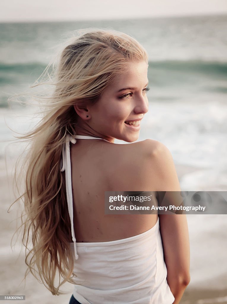 Blond girl on beach looking over shoulder