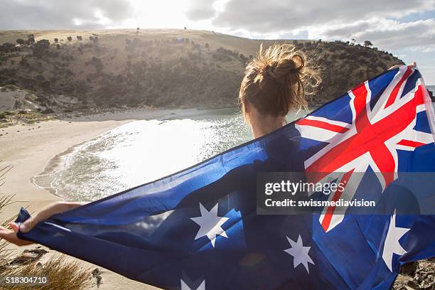 mujer está en viaje de acantilado encima de la playa australiana de retención de la bandera - día de australia fotografías e imágenes de stock