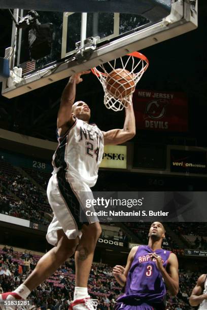 Richard Jefferson of the New Jersey Nets dunks over Loren Woods of the Toronto Raptors on December 6, 2004 at the Continental Airlines Arena in East...
