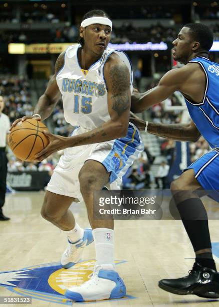 Carmelo Anthony of the Denver Nuggets turns to the basket against DeShawn Stevenson of the Orlando Magic in the first half on December 6, 2004 at the...