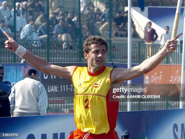 Spanish field hockey player Freixa Santiago raises his arms as he celebrates scoring the third goal against New Zealand during the six-nation...