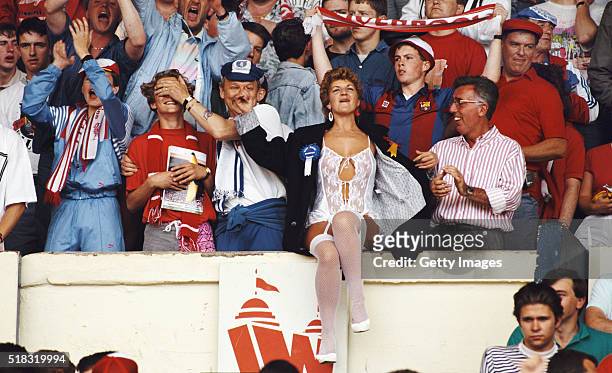 Liverpool and Everton fans share a joke with a scantily clad fan before the 1989 FA Cup Final between Everton and Liverpool at Wembley Stadium on May...