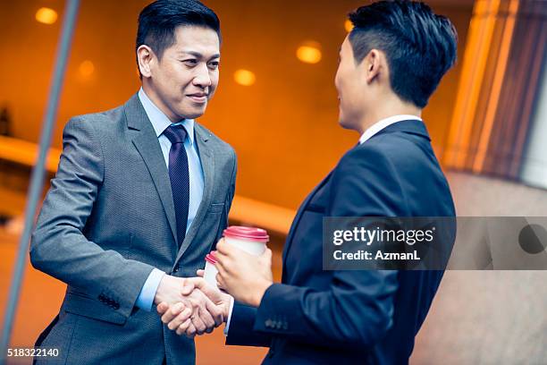 this coffee helped me to clear my mind! - asian shaking hands stockfoto's en -beelden