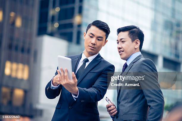 we will build this complex over there! - asian businessman phone stockfoto's en -beelden