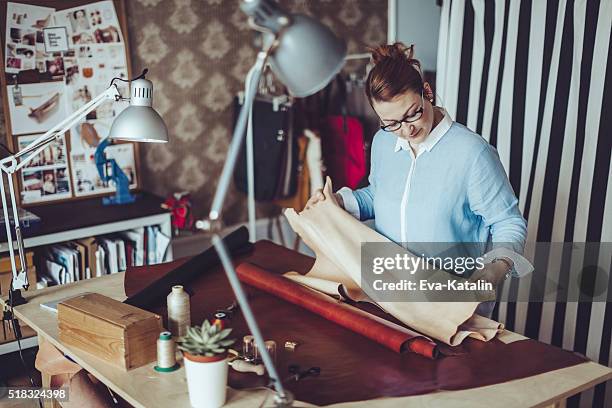 confident craftswoman working in her workshop - fashion designer room stock pictures, royalty-free photos & images
