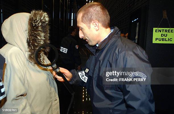 Un policier effectue un controle de securite sur une personne venant temoigner, le 07 decembre 2004 au palais de justice de Nantes, au proces devant...