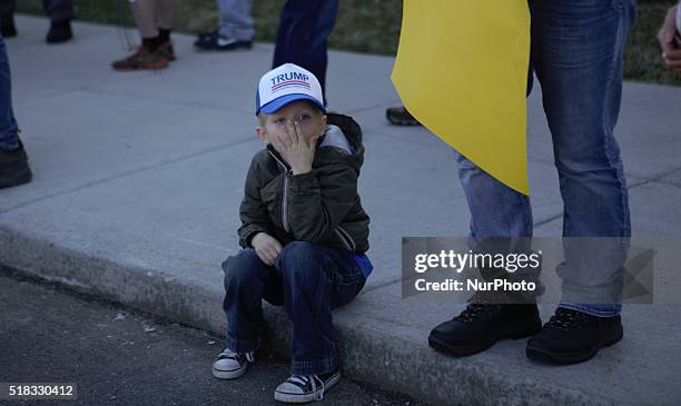 Child wearing a Trump hat sits outside a campaign rally at Holiday Inn Express in Janesville, Wisconsin, United States on March 29, 2016.