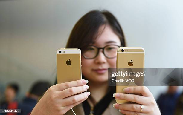 Customer compares rose gold iPhone SE and iPhone 6S at an Apple Store on March 31, 2016 in Hangzhou, Zhejiang Province of China. Apple launched a new...