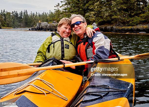 senior couple kayaking - seniors canoeing stock pictures, royalty-free photos & images