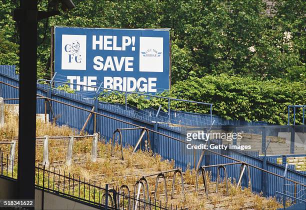 General view of Stamford Bridge, home of Chelsea FC shows a 'Help save the Bridge' sign and it's overgrown terraces, circa 1989 in London, England.
