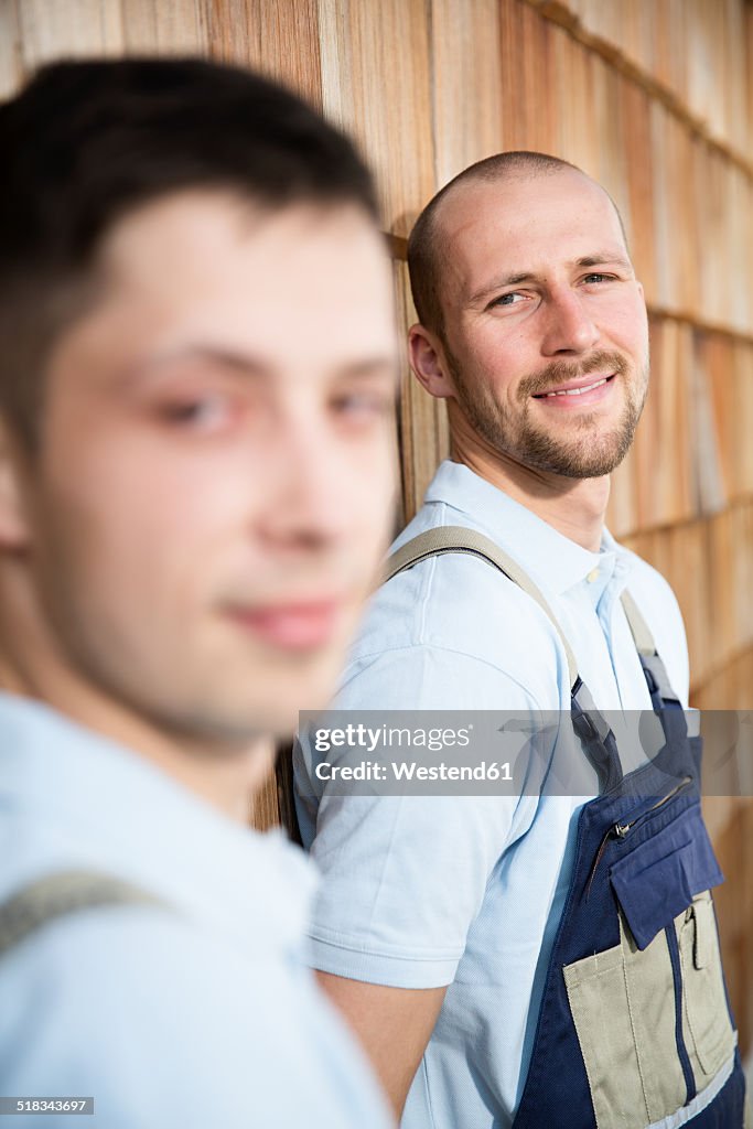 Two craftsmen at wooden wall