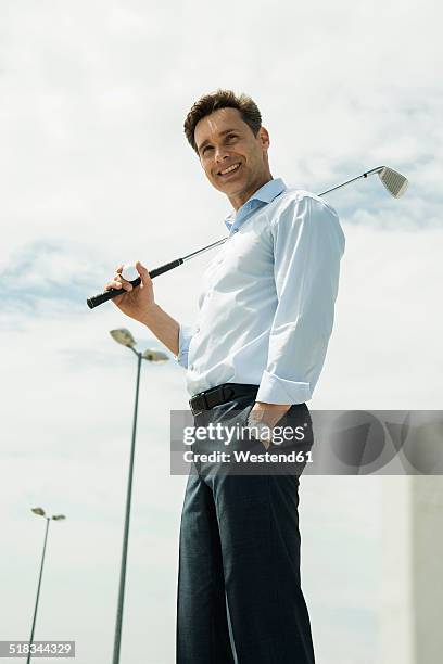 smiling business man with golf club - 肩に乗せる ストックフォトと画像