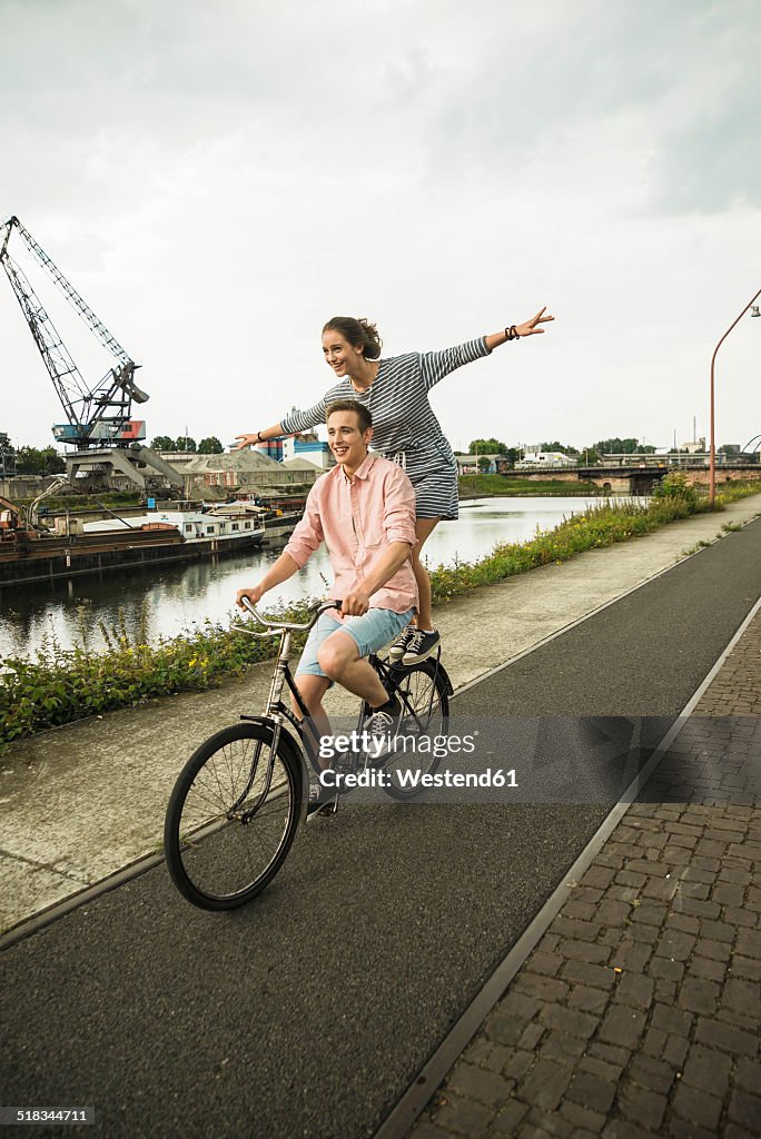 Young couple driving together on bicycle