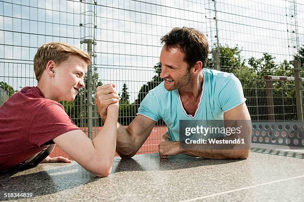 germany, mannheim, father and son arm wrestling - boys wrestling stock pictures, royalty-free photos & images