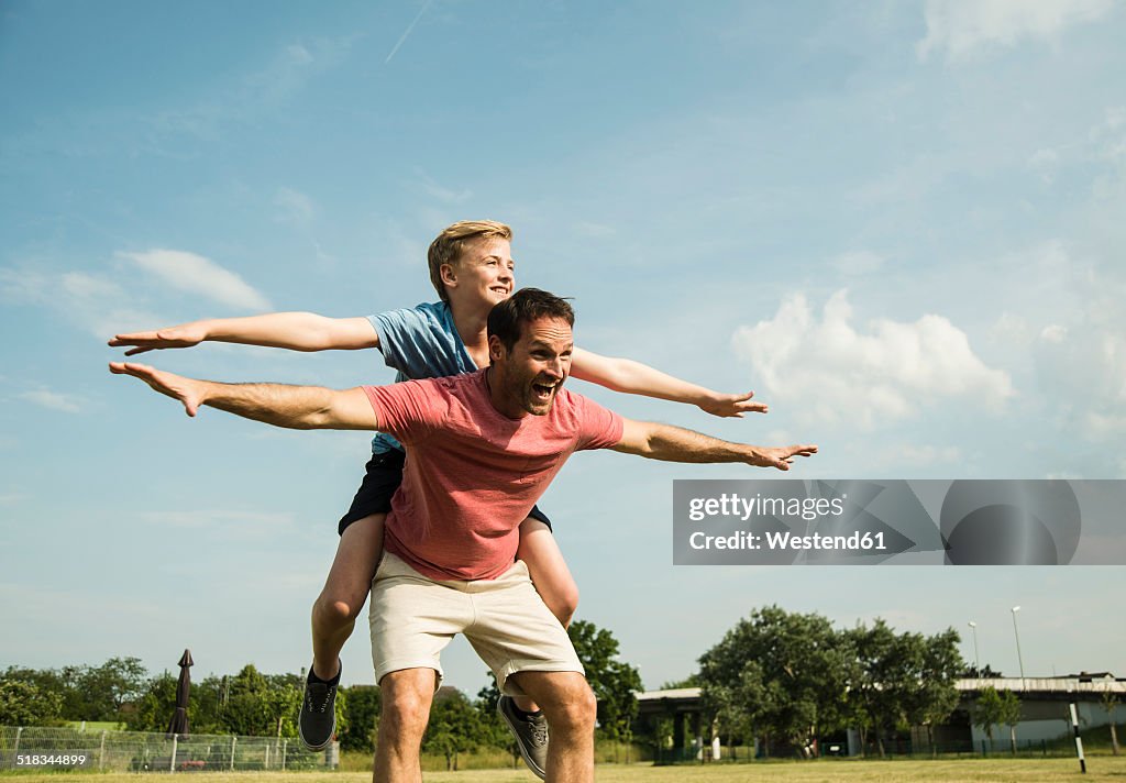 Germany, Mannheim, Father and son pretending to fly