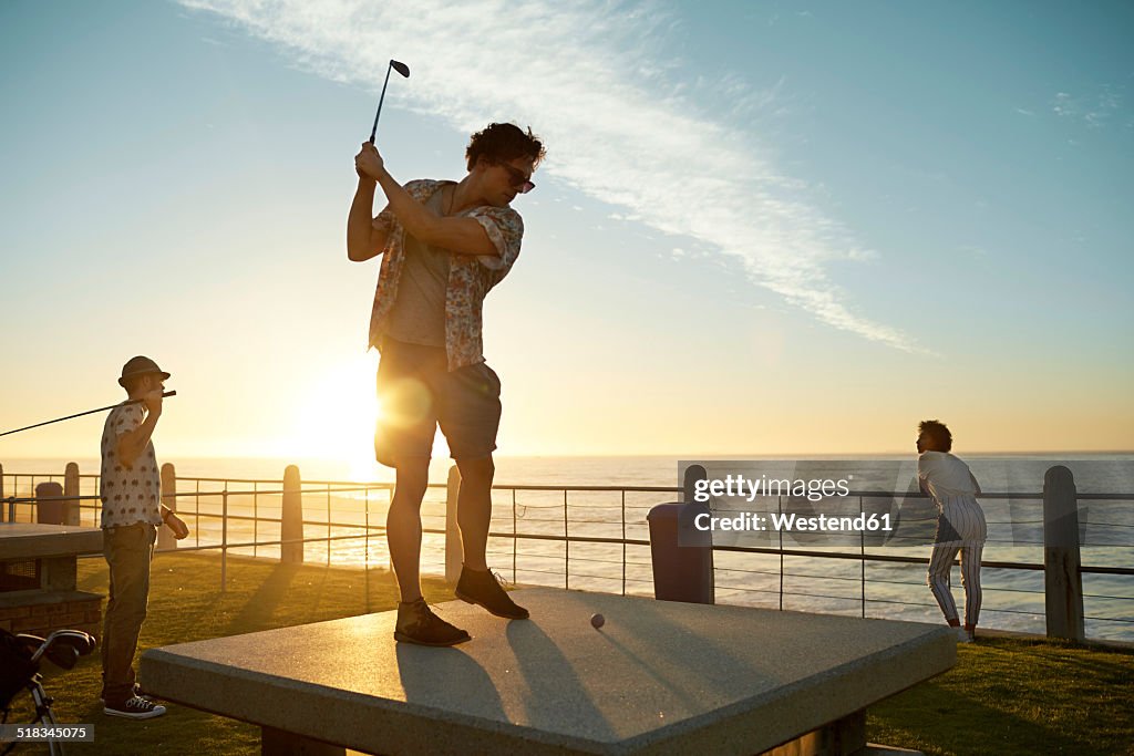 Friends playing urban golf at the coast